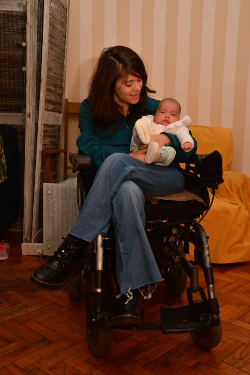 Anabella Mazzini  mirando a su bebe, que tiene en brazos.